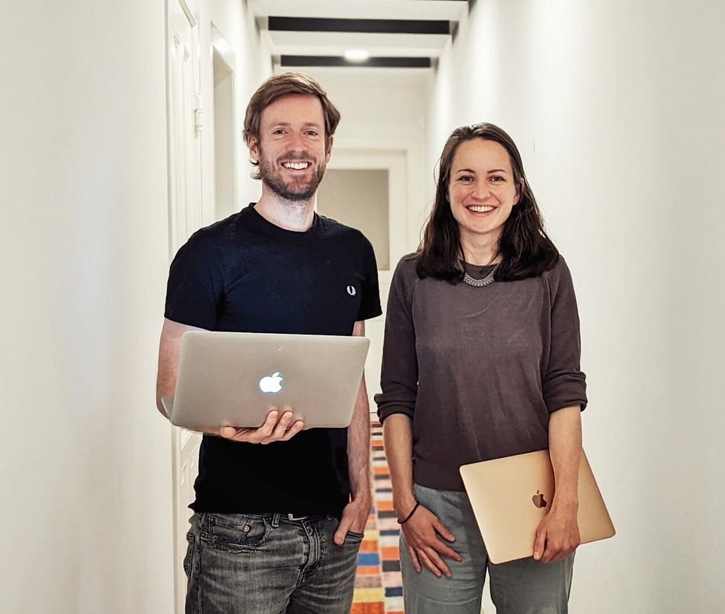 Zwei Menschen in einem Flur mit Laptops in der Hand