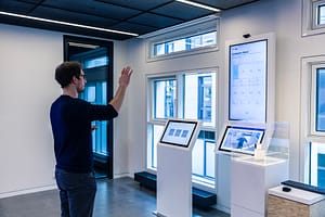 Mann vor Bildschirmen in einem Raum im Showroom