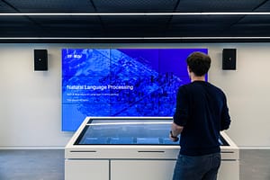 Mann erfährt etwas auf Bildschirm über NLP im Showroom