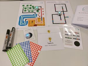 Ozobots auf Tisch mit Strecken und Material