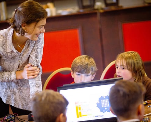 Nina zeigt Betreuerin erklärt KIndern Programmierung