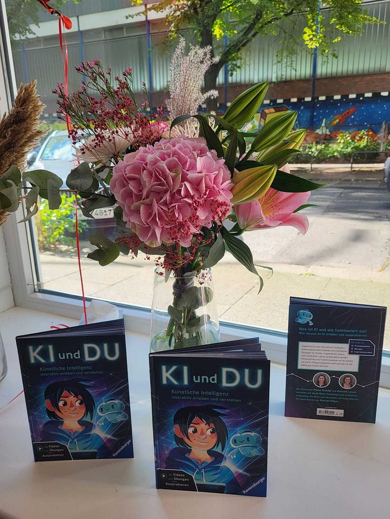 Buch KI und DU im Schaufenster mit einem Blumenstrauß