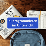 Laptop, Notizbuch und Rucksack auf einem Tisch, Schrift KI im Unterricht