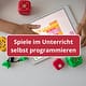 Kinderhand an einem Tablet mit Blöcken, die es programmiert