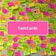 Viele beschriebende Klebezettel an einer Wand und Schrift TaskCards